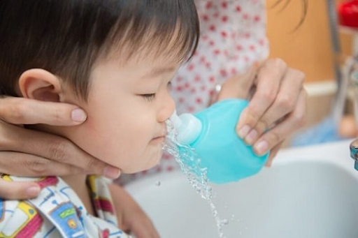 Vệ sinh mũi cho trẻ bằng nước muối sinh lý giúp giảm trình trạng nghẹt mũi, sổ mũi